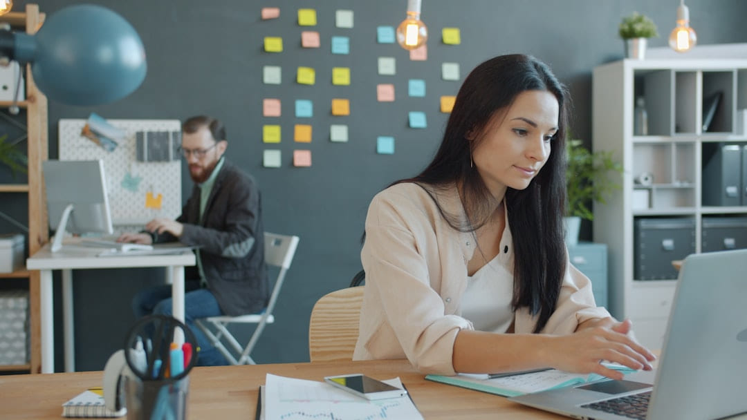 Woman working on a laptop in a modern office. on Small Biz Blueprint
