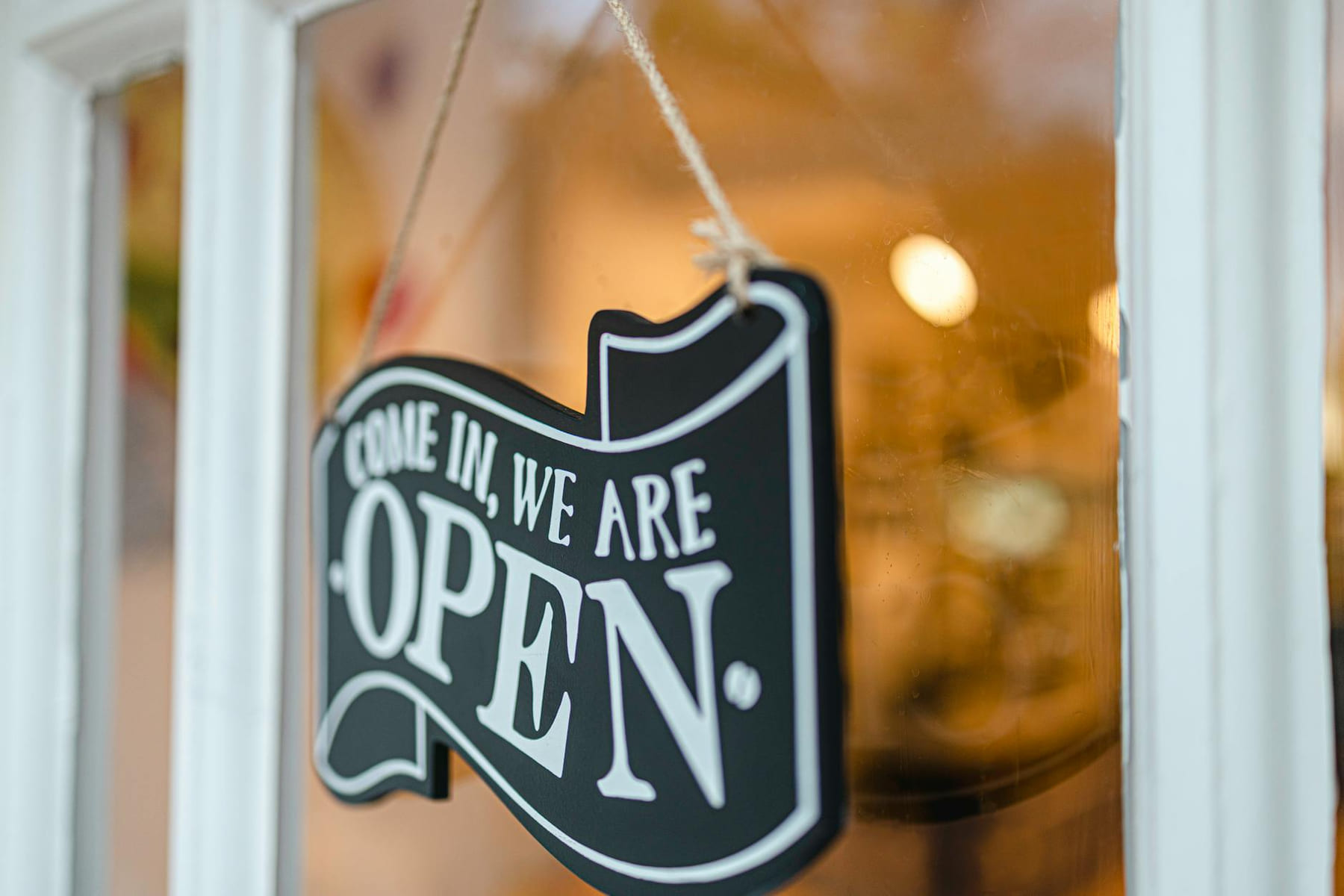A welcoming open sign hanging on a glass door, inviting customers to enter. on Small Biz Blueprint