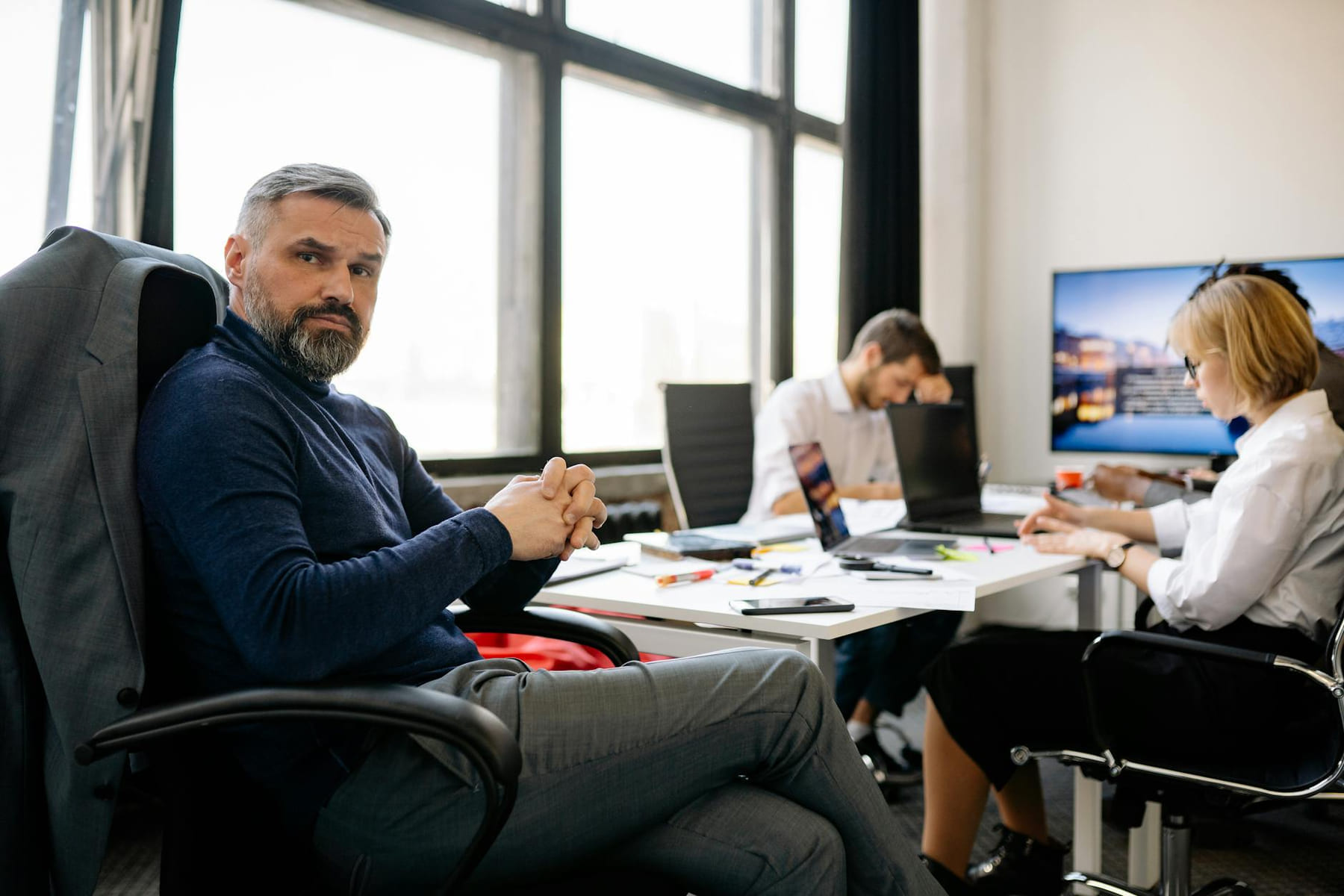 Co-workers engaging in a business discussion in a modern office setting. on Small Biz Blueprint