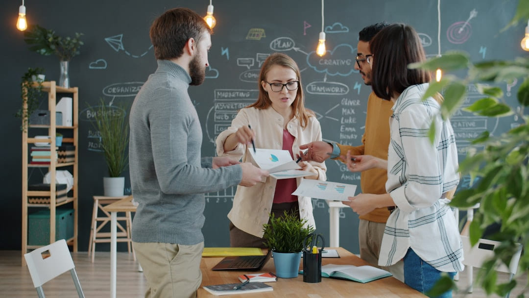 Colleagues collaborating around a table in an office. on Small Biz Blueprint