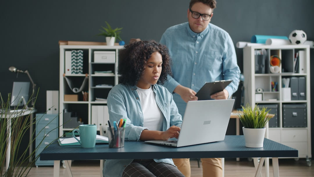Two colleagues working together at a desk. on Small Biz Blueprint