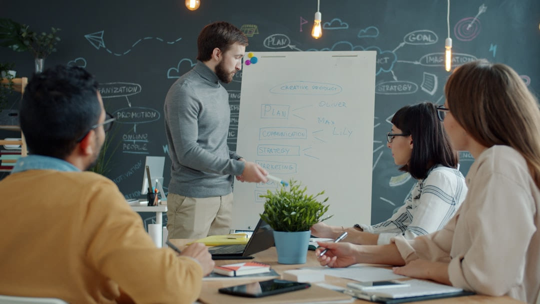 Team collaborating around a whiteboard in a modern office. on Small Biz Blueprint