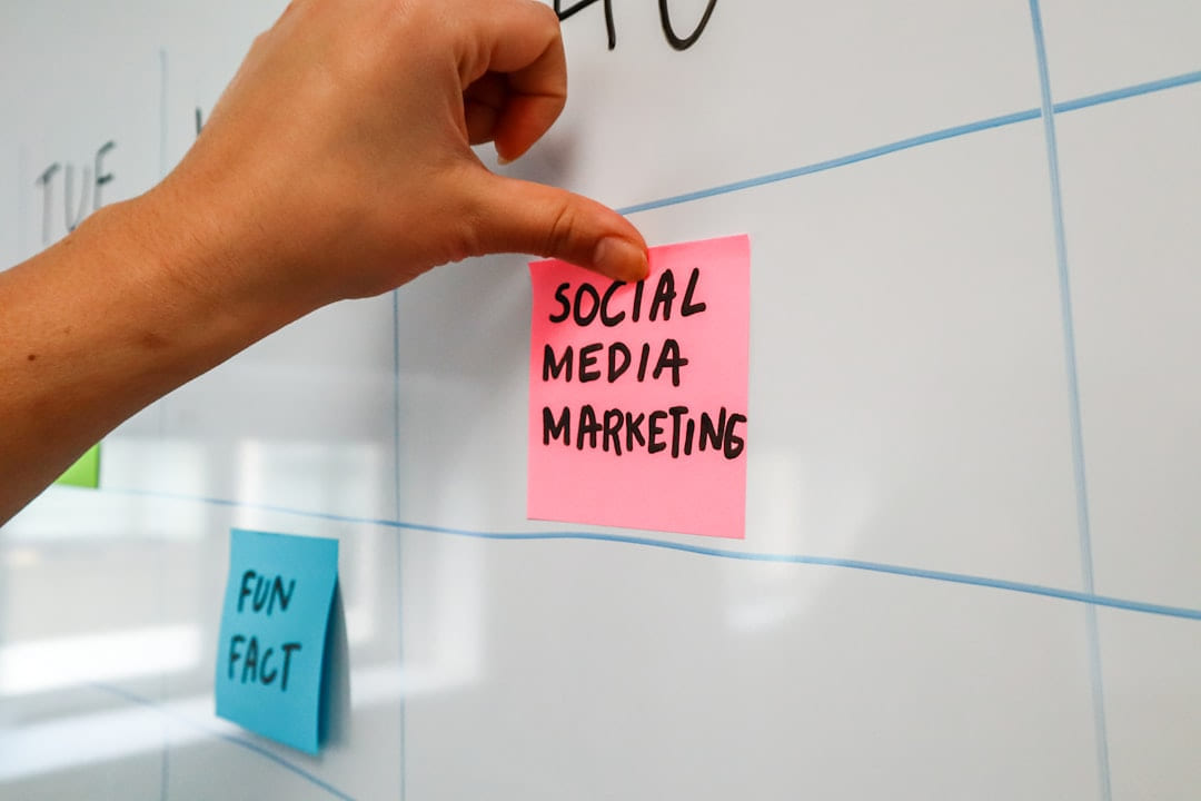 a hand is writing on a sticky note on Small Biz Blueprint