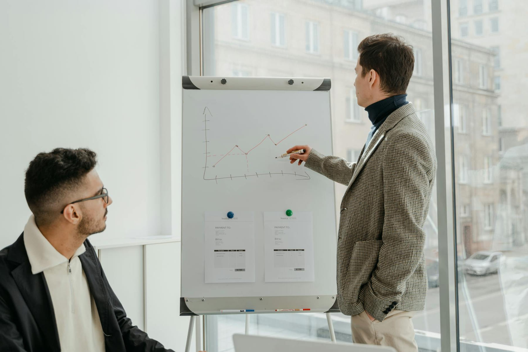 Two professionals examining graphs during an office presentation. on Small Biz Blueprint